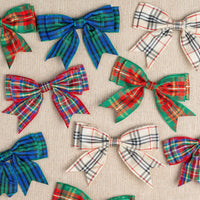 Plaid bows in various colors on a textured beige background