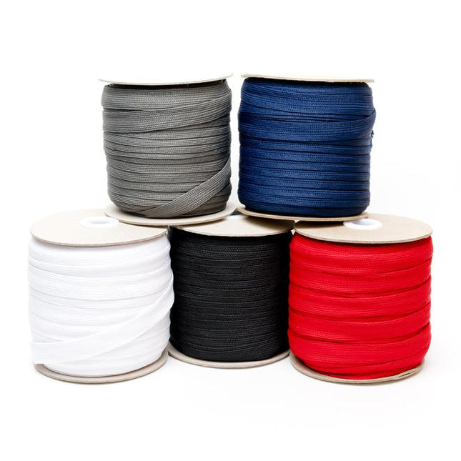 Rolls of flat polyester draw cord in various colors including black, white, grey, blue, and red, intended for use in leisurewear and accessories like wristbands and lanyards.