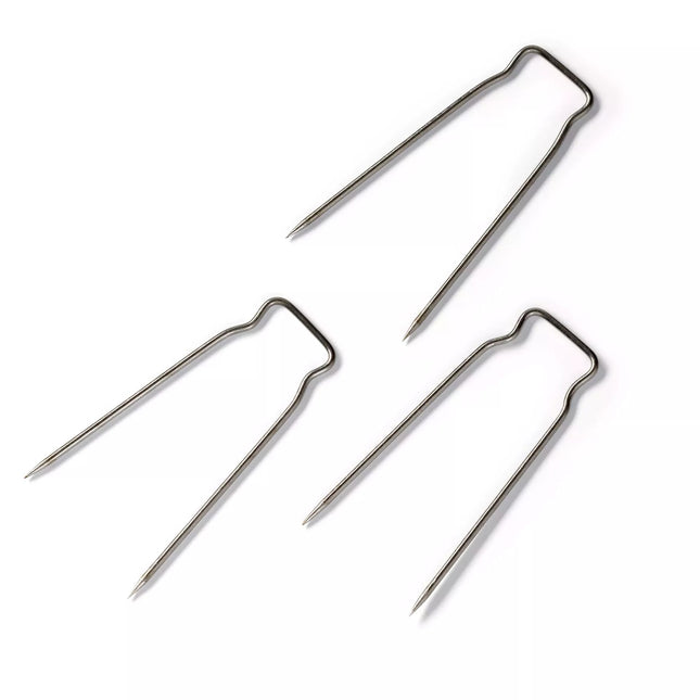 Three metal Prym cover pins for upholstery  on a white background