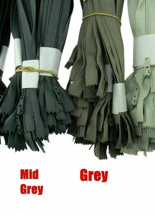 A product display panel showing various neutral shades of grey Trebla nylon coil zippers for tailoring and cushions.
