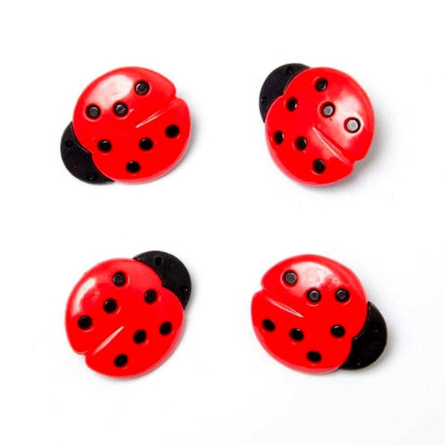 Four red plastic buttons with black ladybird spots and a plastic shank visible on a white background.