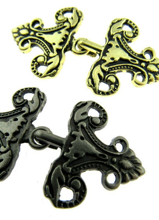 Oriental hook fastener in antique gold and silver on a white background