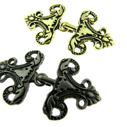 Oriental hook fastener in antique gold and silver on a white background