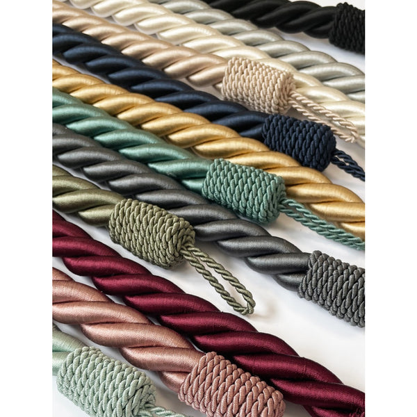 Collection of braided curtain tieback ropes in various colors on a white background