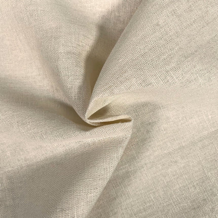 A close-up of draped cream-colored woven fabric with a visible linen-like texture, showing soft folds and shadows.