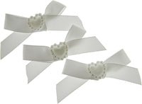 Three white hair bows with pearl centers on a white background