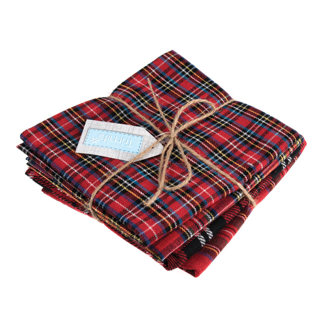 Stack of red plaid tartan fabric fat quarters with twine and a label on a white background