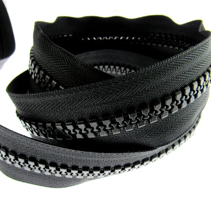 A close-up of a heavy-duty chunky plastic continuous zip chain, showing the teeth and the tape, on a white background.