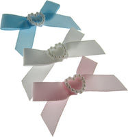 Three ribbon bows with decorative centers on a white background