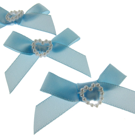 Three light blue hair bows with heart-shaped centers on a white background