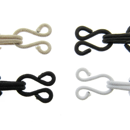 Set of four fur hooks and eyes in beige, black, and white on a white background