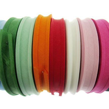 A collection of cotton bias binding bunting tape in various solid colors, including blue, green, orange, pink, white, and black, displayed side by side.