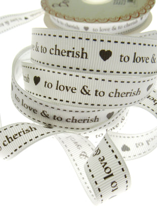 Spool of ribbon with text 'to love & to cherish' on a white background