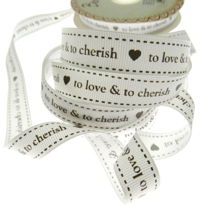 Spool of ribbon with text 'to love & to cherish' on a white background