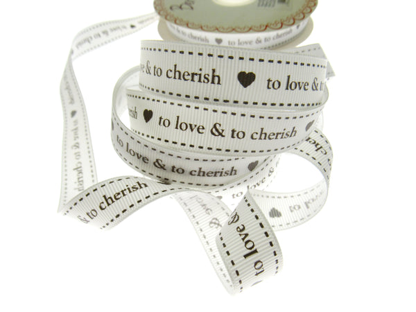 Spool of ribbon with text 'to love & to cherish' on a white background