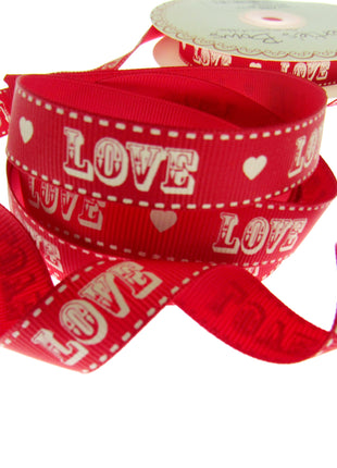 Red ribbon with 'LOVE' and heart patterns on a white background