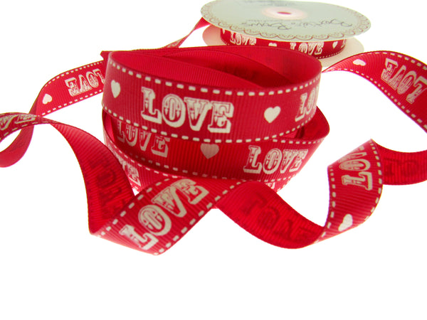 Red ribbon with 'LOVE' and heart patterns on a white background