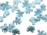 Blue teddy bear-shaped buttons scattered on a white background