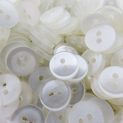 Close-up of a pile of white shirt buttons with two holes.