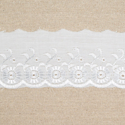 White floral lace trim with scalloped edges and embroidered details, displayed horizontally against a natural beige burlap background.