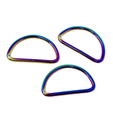 Three metal rings with an iridescent rainbow finish, arranged on a plain white background.