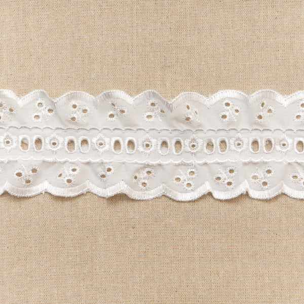 White lace trim on a beige fabric background