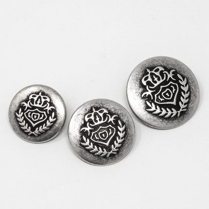 Three round silver-tone decorative buttons with an embossed rose and laurel wreath design, arranged on a plain white background.