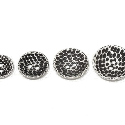 Four round silver-toned metal buttons with a textured black and silver , shown in ascending sizes on a plain white background.