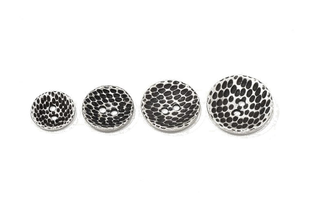 Four round silver-toned metal buttons with a textured black and silver , shown in ascending sizes on a plain white background.