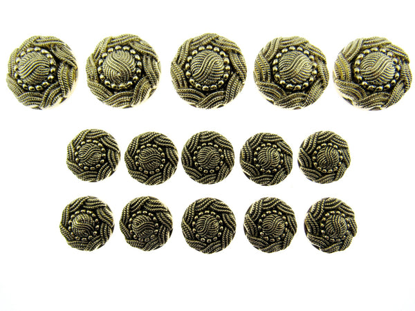 A set of antique gold swirly patterned buttons laid on a white background