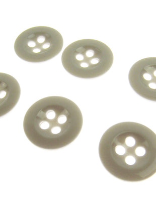Six four hole white trouser buttons on a white background