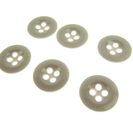 Six four hole white trouser buttons on a white background