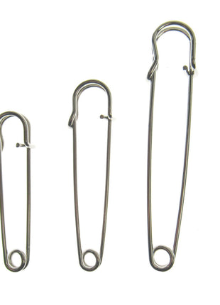 Three nickel plated steel kilt pins in different sizes, isolated on a white background.