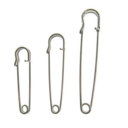 Three nickel plated steel kilt pins in different sizes, isolated on a white background.