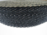 Close-up of a roll of black and white woven Herringbone upholstery webbing on a white background