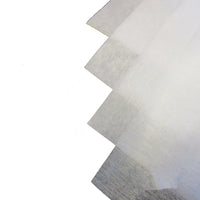 Four sheets of white fusible interfacing material on a white background
