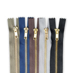 Set of metal jean zippers in various colours on a white background
