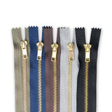 Set of metal jean zippers in various colours on a white background