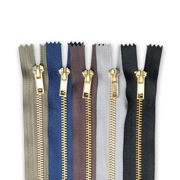 Set of metal jean zippers in various colours on a white background