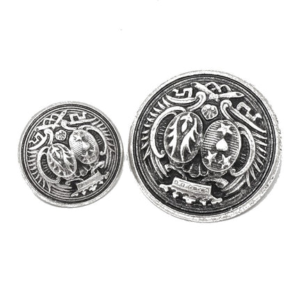 Two round silver-toned decorative buttons with embossed heraldic designs, shown on a plain white background.