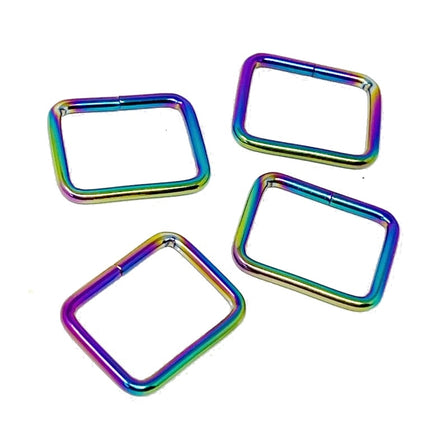 Four square-shaped metal rings with rounded corners, featuring an iridescent rainbow finish, arranged on a plain white background.