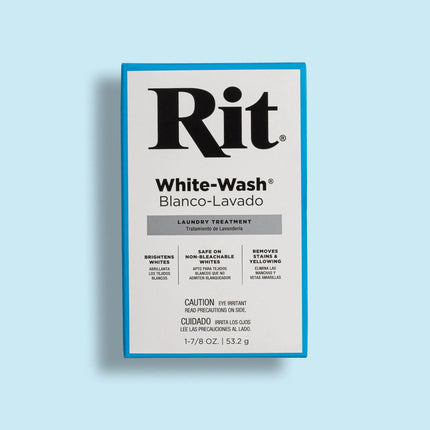 A boxed laundry treatment package labeled Rit White-Wash / Blanco-Lavado, shown upright on a light blue background. The package is mostly white with a bright blue border and large black Rit branding.
