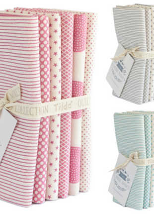 A set of TILDA 6 folded fat quarters of cotton fabric in various patterns including stripes and dots, bound together with a fabric tie and tags indicating the brand.