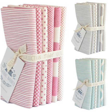 A set of TILDA 6 folded fat quarters of cotton fabric in various patterns including stripes and dots, bound together with a fabric tie and tags indicating the brand.