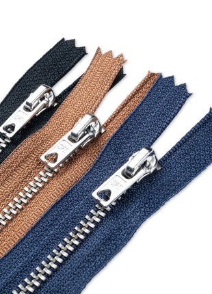 Three zippers in blue, brown, and black with metal pullers on a white background