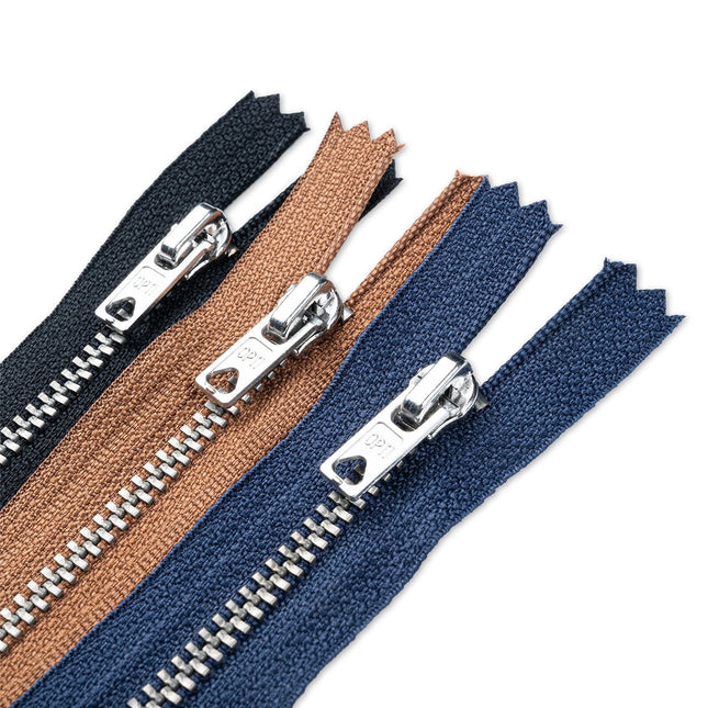 Three zippers in blue, brown, and black with metal pullers on a white background