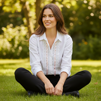 Woman sitting on grass in black trousers and white blouse with white broderie anglaise insertion lace and pale pink satin ribbon woven through eyelets on button placket — Thread and Trimmings