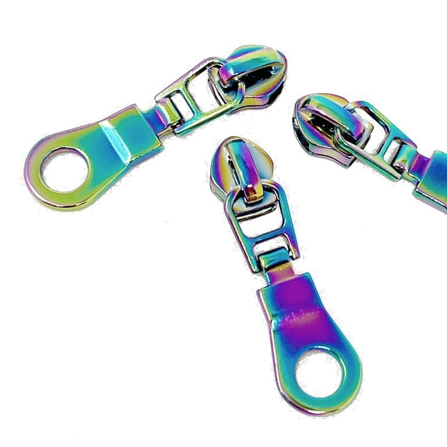 Three metallic zip sliders with an iridescent rainbow finish, displayed on a clean white background.