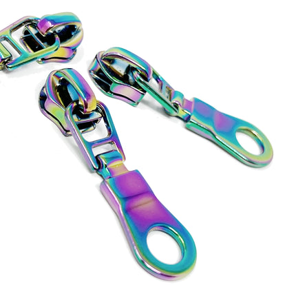 Metallic rainbow-colored zipper sliders on a white background