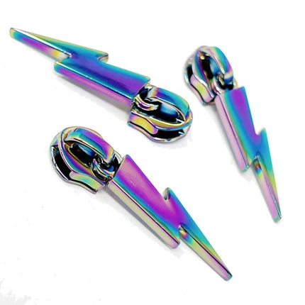 Three metallic lightning bolt-shaped zips sliders with an iridescent rainbow finish, arranged on a plain white background.